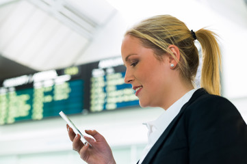 Frau schreibt eine SMS mit ihrem Handy