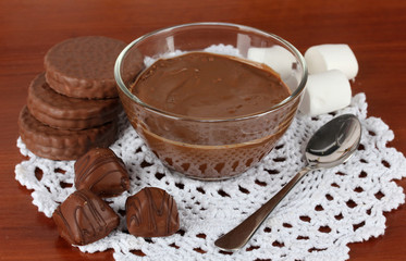 Bowl of chocolate and sweets on wooden background