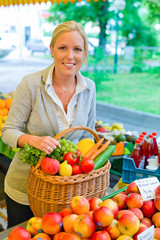 Frau am Obstmarkt mit Einkaufskorb