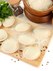 Raw dumplings and ingredients on wooden desk, isolated on white