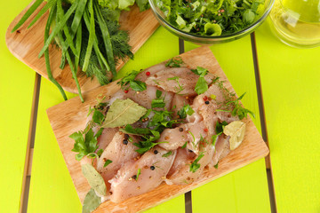 Chicken meat in glass plate,herbs and spices on wooden table