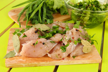 Chicken meat in glass plate,herbs and spices on wooden table