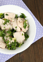 Boiled meat on plate on napkin on wooden table