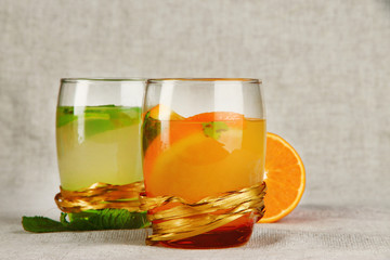 Lemonade in glasses on fabric background close-up