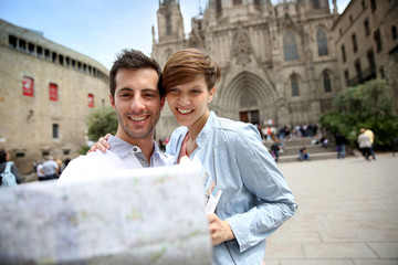 Couple looking at touristic map by Barcelona Cathedral