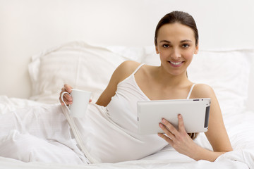 Young girl using  tablet on bed