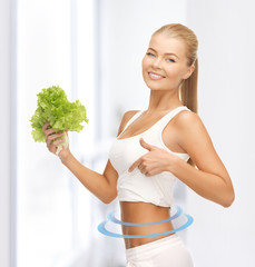 sporty woman with lettuce showing abs