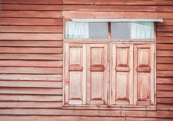 Closed vintage wooden window on wooden wall
