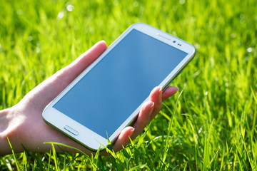 Woman Hand Holding Smart Phone on Green Background