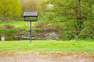 peaceful nature area with lake and bird table