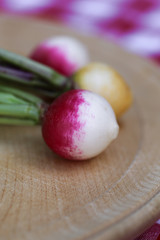 Delicious radishes on wooden plate