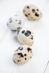 Vertical shot of raw quail eggs on wooden boards