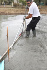 Man spreading concrete foundation