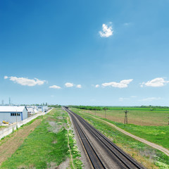 Fototapeta na wymiar railroad in green fields and blue sky