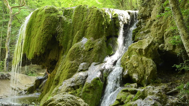 Man in grotto under a waterfall