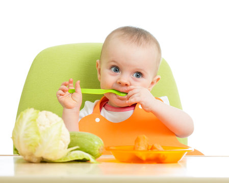 happy baby girl eating vegetables
