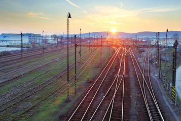 Railroad with train at sunset and many lines