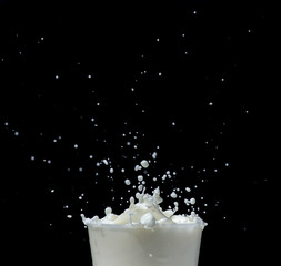 Splashing milk on black background