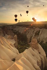 Tuinposter Hot air balloon over rock formations in Cappadocia, Turkey © Anton Petrus