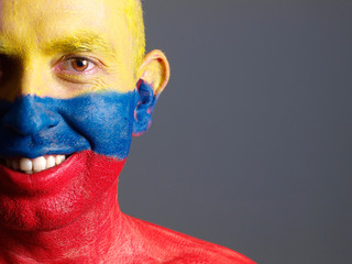 Man face painted with colombian flag, smiling expression