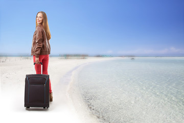 Fototapeta premium Woman with a suitcase on the beach