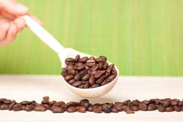 coffee beans on wooden surface with wooden spoon