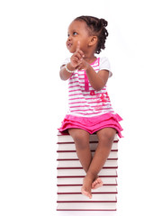 Cute black african american little girl seated in a stack of boo