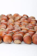 Unbroken hazelnuts on white surface
