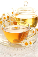 Cup of herbal tea with camomiles close up