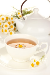 Cup of herbal tea with camomiles close up