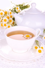 Cup of herbal tea with camomiles close up