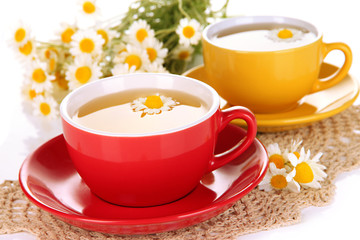 Cups of herbal tea with camomiles close up