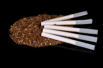 Tobacco and cigarette tubes, isolated on black