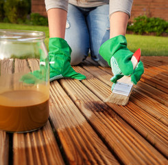 Applying protective varnish on a patio wooden floor - 52458270
