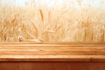 Empty wooden deck over wheat field background