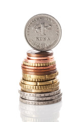 A standing 1 kuna coin - Croatian currency - on top of the stack