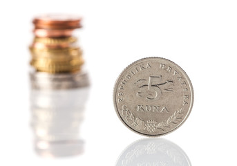 A standing 5 kuna coin - Croatian currency - in front of the sta