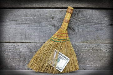 Image of broom with dollars, close-up
