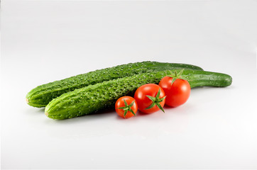 Two cucumbers and three tomatoes on the white background