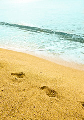 Fototapeta na wymiar Footprint on sand with foam
