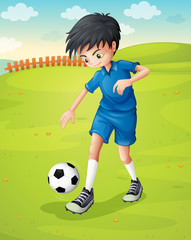 A boy with a blue uniform practicing at the hillside