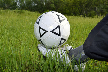 soccer ball on his foot against the grass