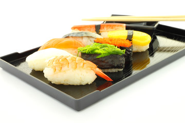 Sushi black rectangle plate focus shrimp on white table.
