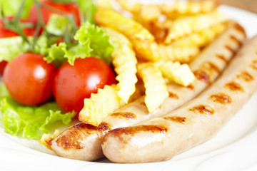 grilles sausages with french fries and salad