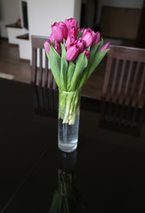 tulips in vase on table in home
