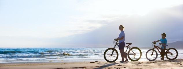 Mother and son biking at beach