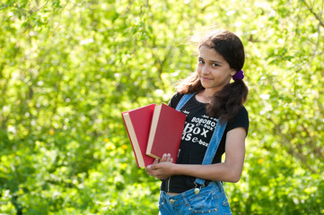 Fototapeta premium Teen girl with books on nature