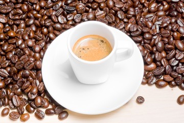 top of view of white cup with espresso coffee near coffee beans