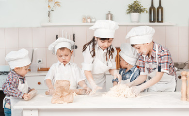 happy little chefs preparing dough in the kitchen