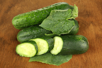 Tasty green cucumbers on wooden background